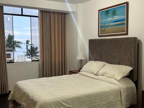 a bedroom with a bed and a large window at Lindo apartamento en Huanchaco, con vista al mar in Huanchaco