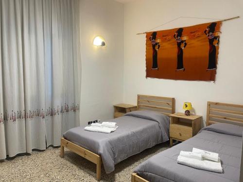 Zimmer mit 2 Betten und einem Fenster in der Unterkunft Beteyà Hostel Don Bosco in Catania
