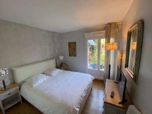 - une chambre avec un lit blanc et une fenêtre dans l'établissement Appartement Cosy, tout confort, à deux pas de la mer, à Deauville