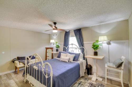 um quarto com uma cama azul e uma ventoinha de tecto em Rural Mississippi Vacation Rental about 12 Mi to Lake! em Prentiss