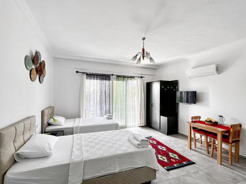 a bedroom with two beds and a table in it at Kaş Merkezde Konforlu Apart-2 The Rush-2 in Kas