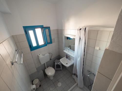 a bathroom with a toilet and a sink and a mirror at Hellas in Palekastron