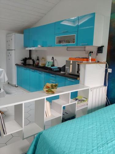 eine blau-weiße Küche mit blauen Schränken in der Unterkunft Studio cocooning in Le Porge