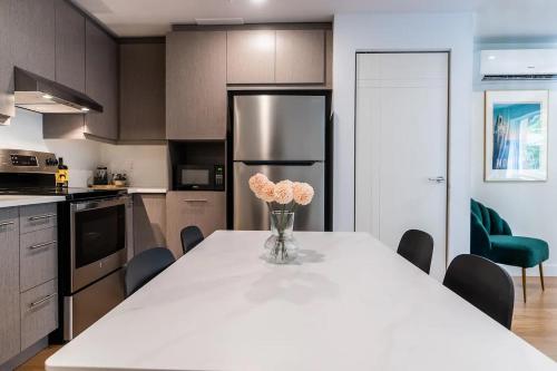 a kitchen with a table with a vase of flowers on it at Rozenhaus Montreal Hotel in Montréal