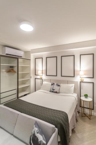 a bedroom with a large white bed and two lamps at Charlie Porto Alegre Moinhos in Porto Alegre