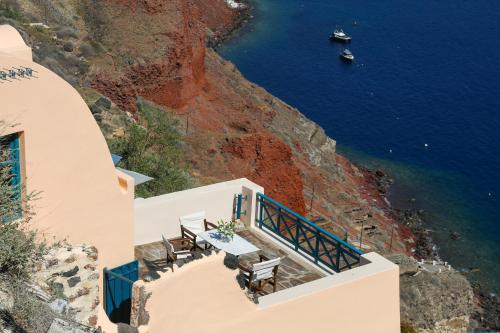 ein Restaurant an der Seite einer Klippe mit Blick auf den Ozean in der Unterkunft Oia VineyART Homes in Oia