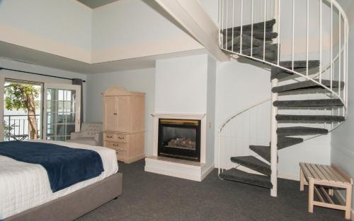 a bedroom with a spiral staircase and a fireplace at The Sand Hill Inn in Lake Geneva