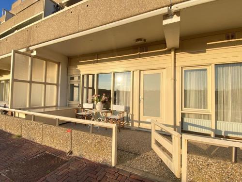 a building with a balcony with a table and chairs at Amstel BeachHouse Egmond aan Zee, 50m from the beach! in Egmond aan Zee