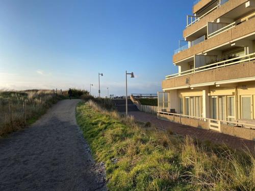 a dirt road next to a building on the beach at Amstel BeachHouse Egmond aan Zee, 50m from the beach! in Egmond aan Zee