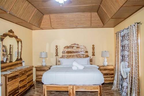 a bedroom with a large bed and a mirror at Blue Berry Hill Villa in Discovery Bay