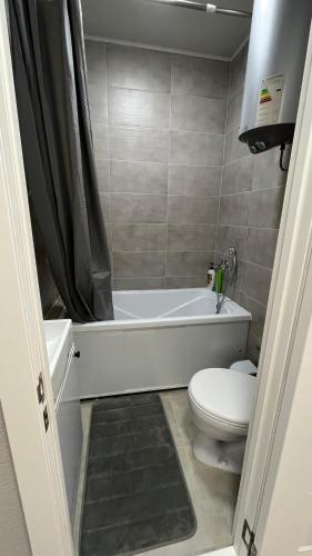 een badkamer met een wit bad en een toilet bij Квартира 6-35 in Aqtau