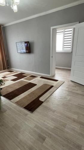 una sala de estar vacía con una alfombra en el suelo en Квартира 6-35, en Aktau