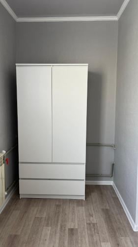 a white cabinet in the corner of a room at Квартира 6-35 in Aktau