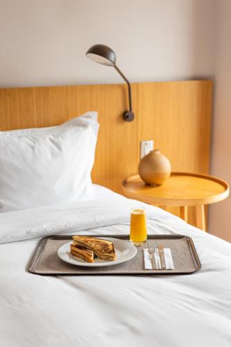 a tray with a plate of food on a bed at B Hotel Brasilia in Brasilia