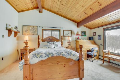 Schlafzimmer mit einem Holzbett und einem Schreibtisch in der Unterkunft Cozy Mountain Home on 10 Acres with Fire Pit and Games in Thayne
