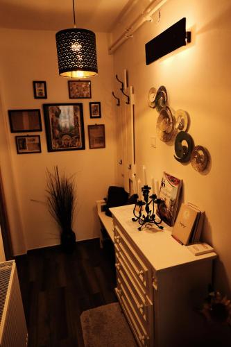 a room with a desk with a lamp and some pictures on the wall at Kisház Apartman in Eger