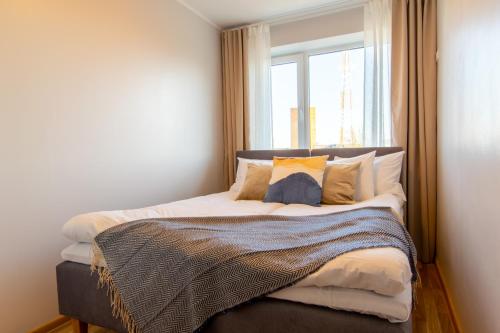 a bed in a room with a window at Stylish Central Apartment by Kuus Sõlme in Kuressaare