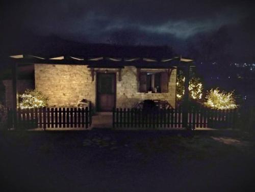 una casa con una valla delante de ella por la noche en Μικρό σαλέ., 