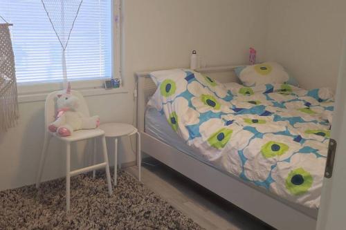 Dormitorio infantil con cama y silla en 100m2 moderni paritalo omalla pihalla Helsingissa en Helsinki