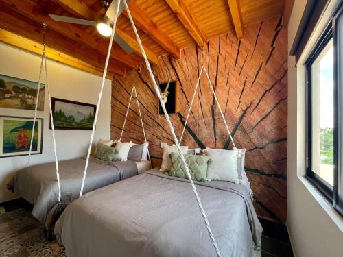 2 camas en una habitación con paredes de madera en Golf Villa con Jacuzzi y rooftop, en San Miguel de Allende