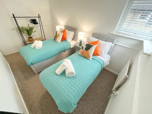 two beds with pillows in a small room at 2 Bedroom Flat - Free Parking in Shenley Church End