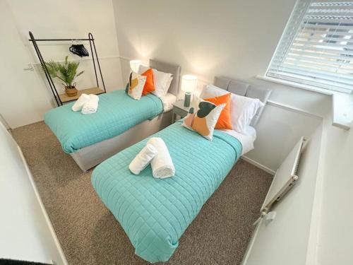 Duas camas com almofadas num pequeno quarto em 2 Bedroom Flat - Free Parking em Shenley Church End