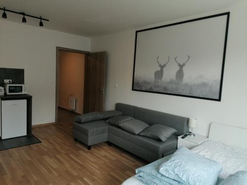 uma sala de estar com um sofá e dois veados na parede em Brand new studio apartment #51 with free secure parking in the center em Praga