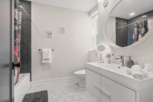 La salle de bains blanche est pourvue d'un lavabo et d'un miroir. dans l'établissement Family Fun South Philly Game House Near Sports Stadiums and Concerts, à Philadelphie