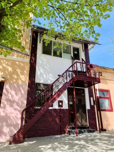 une maison en briques avec un escalier rouge. dans l'établissement Casa Pitaru, à Calafat
