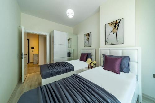 um quarto com 2 camas e almofadas roxas em Modern Apartment with Shared Sauna in Alanya em Kargicak