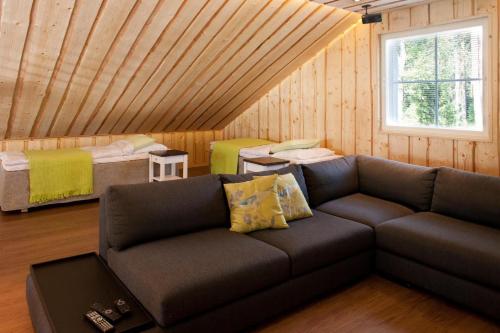 a living room with a couch and two beds at Villa Kilpikonna in Mikkeli
