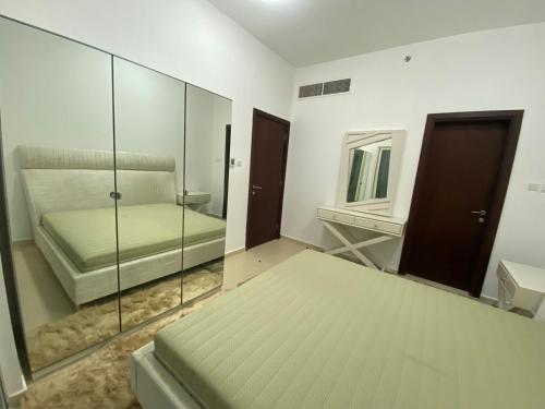 ein weißes Zimmer mit einem Bett und einem Spiegel in der Unterkunft OWN APARTMENT in Ajman 