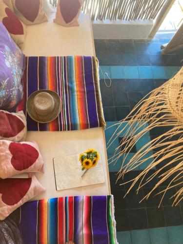 a table with a plate of flowers and a hat on it at Casa Love in Sayulita