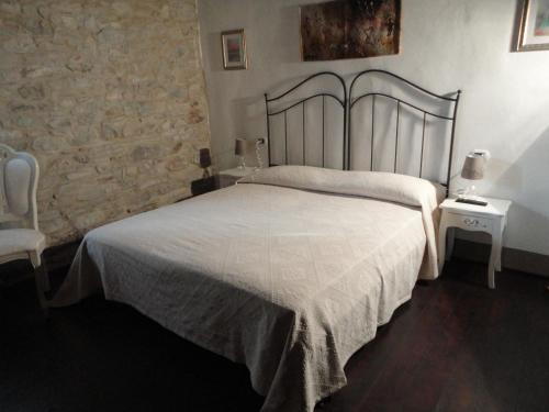 a bedroom with a large white bed and two tables at Casa Shalom in Pennabilli