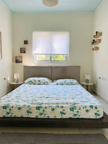 um quarto com uma cama grande e uma janela em Grandpa’s cottage em Nea Makri