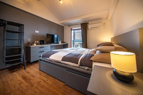 um quarto com uma cama e uma mesa com um candeeiro em Studio Apartment Kos**** em Opatija