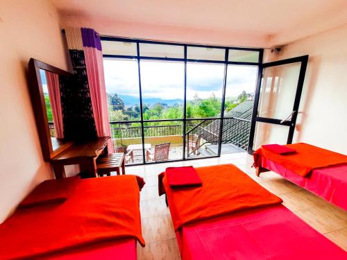 a room with two beds and a large window at Awinco Haputale in Haputale