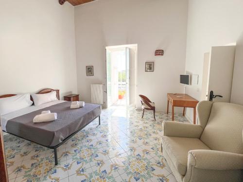 a bedroom with a bed and a chair and a desk at Casa Niná in Vietri sul Mare