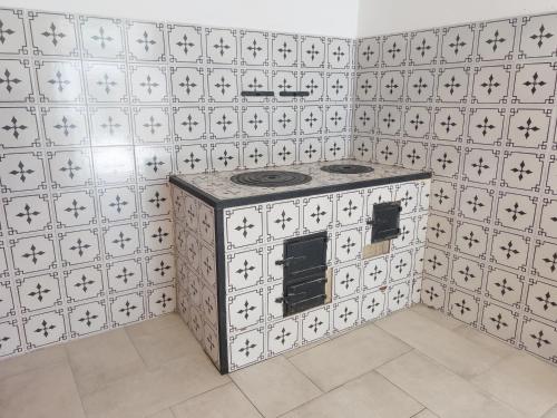 uma cozinha com um fogão numa parede de azulejos brancos em Casa Niná em Vietri