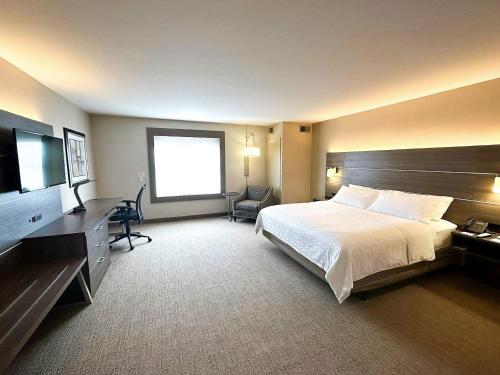 een hotelkamer met een bed en een flatscreen-tv bij Holiday Inn Express & Suites Plymouth - Ann Arbor Area, an IHG Hotel in Plymouth