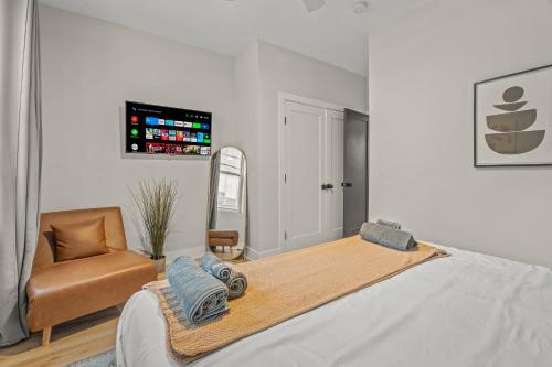 a bedroom with a large bed and a chair at Kid-Friendly Fishtown Family Retreat with Game Room in Philadelphia