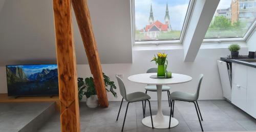 リュブリャナにあるFeel & Enjoy Ljubljanaの窓付きのキッチン(小さな白いテーブルと椅子付)