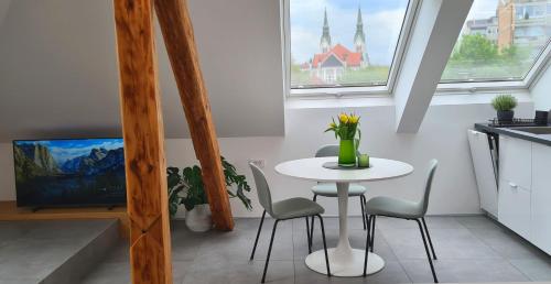 リュブリャナにあるRelax & Enjoy Ljubljanaの窓付きのキッチン(小さな白いテーブルと椅子付)