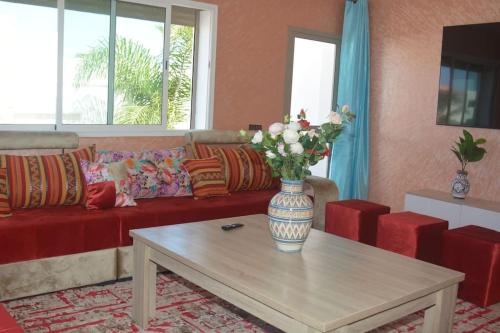 a living room with a vase of flowers on a coffee table at Oualidia29 in Oualidia