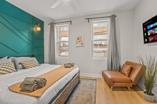 a bedroom with a large bed and a chair at Kid-Friendly Fishtown Family Retreat with Game Room in Philadelphia