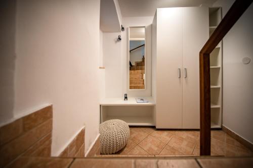 um corredor com uma cadeira e um armário branco em Studio Apartment Kos**** em Opatija