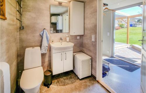 y baño con aseo, lavabo y espejo. en Stunning Home In Romelanda With Kitchen en Romelanda