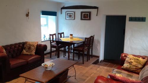 a living room with a couch and a table at The Rockhouse - Cosy stone built Thatch Cottage in Dungloe