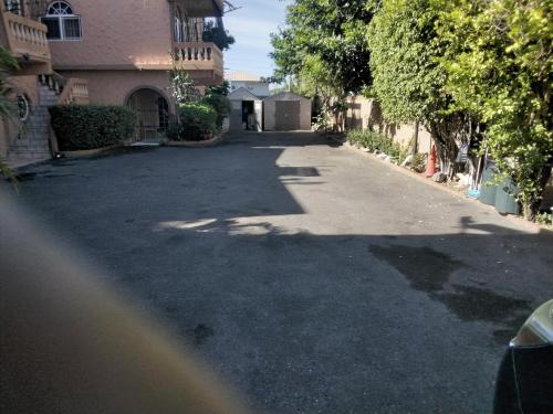 an empty street in a residential neighborhood with trees at Cozy Apartment 4 in Kingston