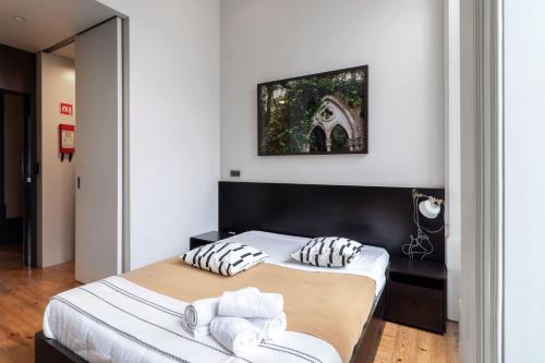 Un dormitorio con dos camas y un cuadro en la pared. en Despertar Saudade, en Coímbra